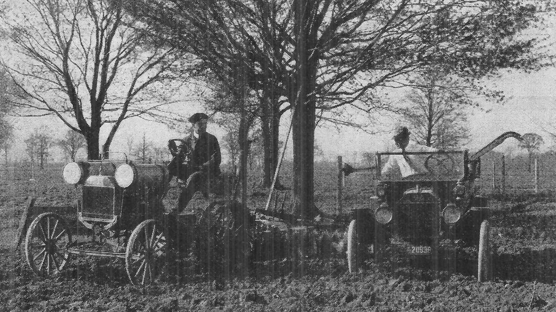 Picture of two old 1900s Ford Model T's sitting in a field.