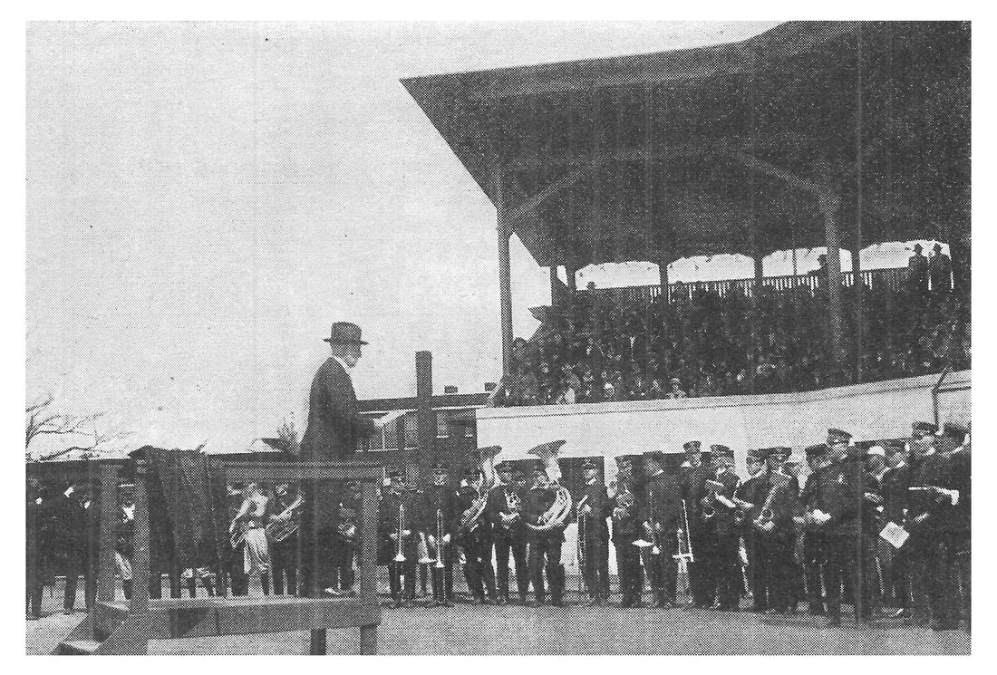 Picture of George Verity speaking to employees at a company baseball game.