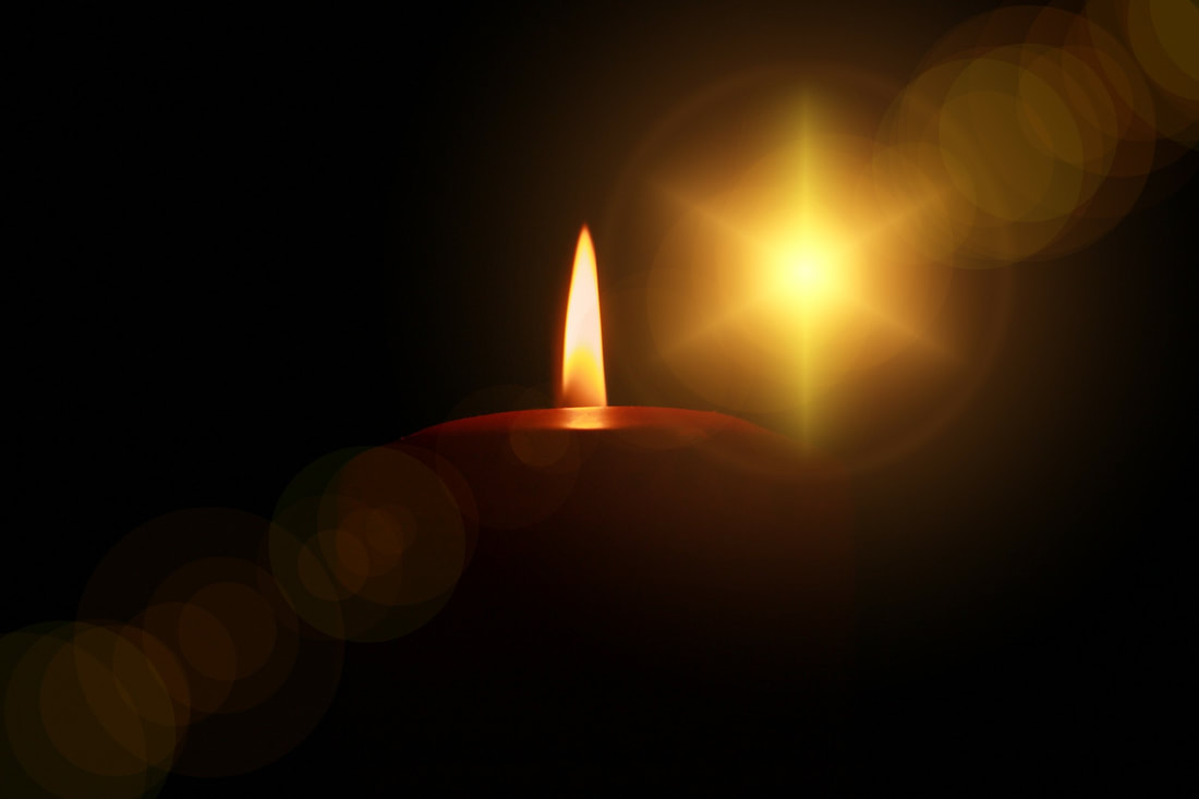 Image of two candles lite against the darkness.