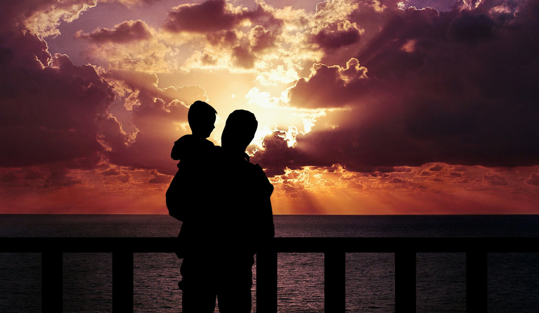 Father and child looking at sunset.