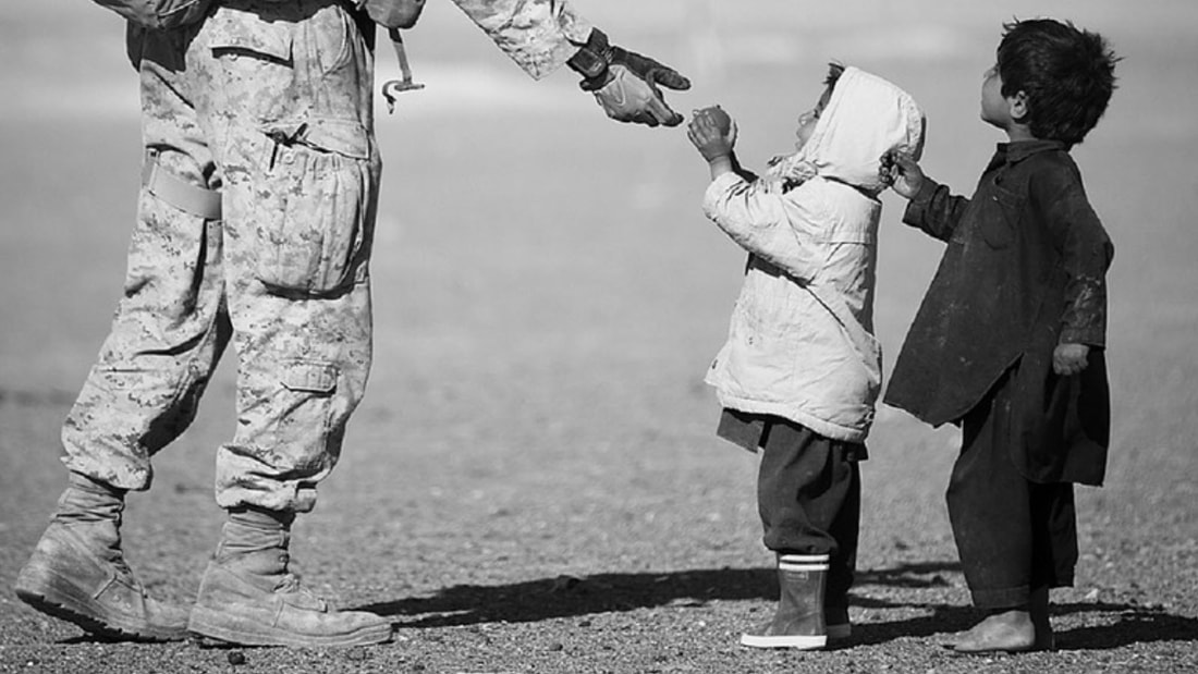 Image of soldier giving chocolate to children.