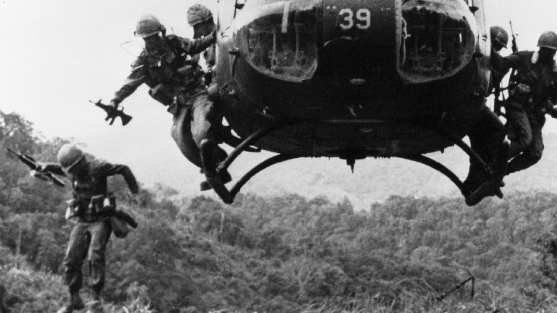 Image of American soldiers jumping into the jungle of Vietnam.